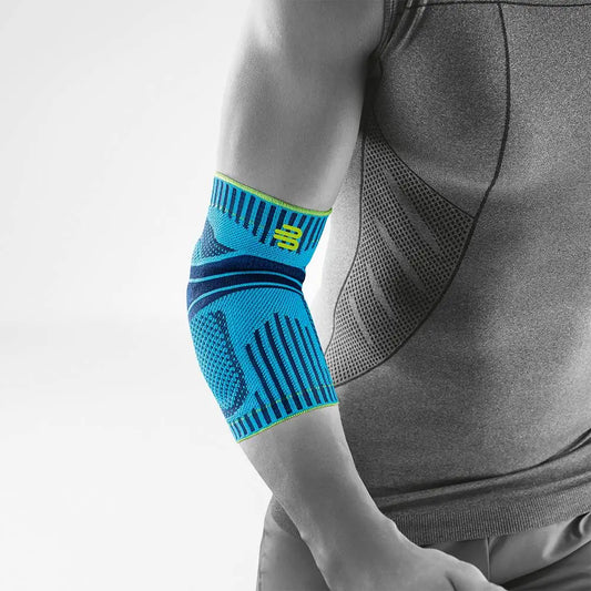 Die Abbildung zeigt den Bauerfeind Sports Elbow Support, eine sportliche Ellenbogenbandage, die zur Unterstützung und Stabilisierung des Ellenbogengelenks während körperlicher Aktivität entwickelt wurde. Die Bandage besteht aus atmungsaktivem, komprimierendem Material, das sich eng an den Ellenbogen anschmiegt und die Muskulatur aktiviert. Sie ist mit anatomisch geformten Pelotten ausgestattet, die gezielten Druck ausüben, um Schmerzen zu lindern und die Gelenkführung zu verbessern. 