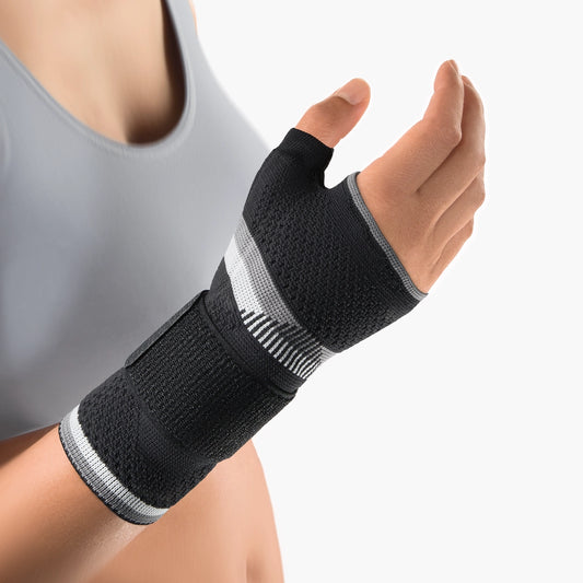 Die Abbildung zeigt die Bort ManuBasic Plus Handbandage, eine stabilisierende Bandage für das Handgelenk und den Daumen. Sie besteht aus elastischem, atmungsaktivem Material und verfügt über eine verstärkte Schiene, die das Handgelenk in einer neutralen Position fixiert und den Daumen zusätzlich stabilisiert. Diese Bandage ist besonders hilfreich bei Beschwerden wie Sehnenscheidenentzündung, Arthrose oder nach Verletzungen.