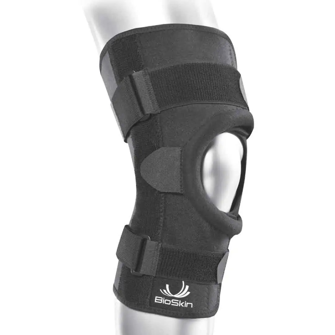 Das Bild zeigt die BioSkin Q Brace CrossFire Kniebandage, eine schlanke und ergonomisch Bandage, die das Knie stabilisiert. Die offene Patellaposition entlastet den Druck auf die Kniescheibe, während das Kreuzgurtsystem seitliche Stabilität gewährleistet.